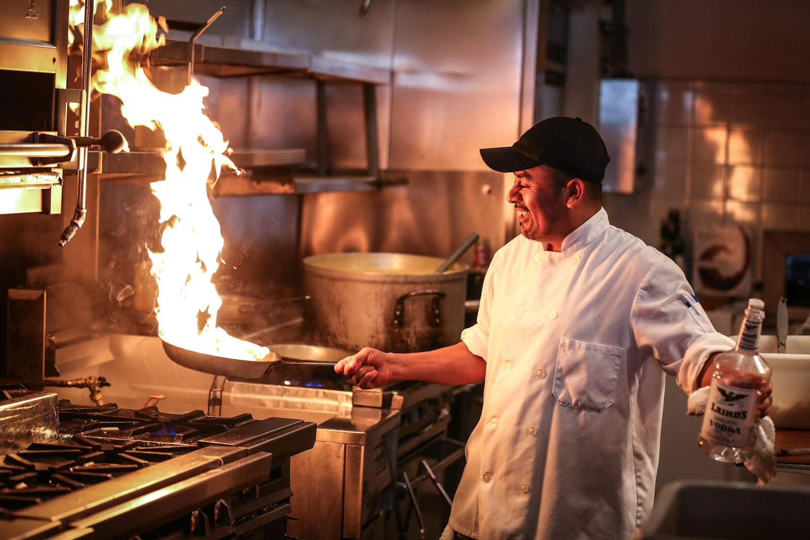 Chef cooking on a commercial gas range in a restaurant kitchen